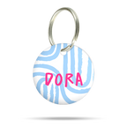 Personalisierte Hundemarke aus Acryl mit blauen Kringel auf weißem Hintergrund, leicht, geräuschlos und klimperfrei, Namensschild mit pinken Namen „Dora“