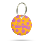 Personalisierte Hundemarke aus Acryl in Neon Orange mit lila Punktmuster und dem Namen Murphy auf weißem Hintergrund.