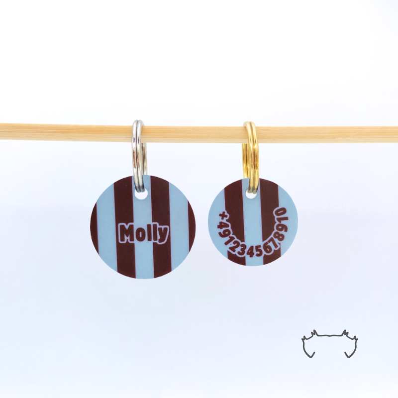 Zwei runde personalisierte Acryl-Hundemarken mit blau-bordeauxfarbenem Streifenmuster an einer hellen Holzstange, vorne mit Name „Molly“ und hinten mit Telefonnummer.
