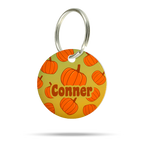 Runde personalisierte Herbst Hundemarke aus Acryl mit orangefarbenen Kürbissen, Name Conner und silberfarbenem Metallring.