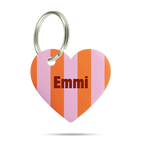 Formgeschnittene Acryl-Hundemarke in Herzform mit rosa, orange und pinkem Streifenmuster, personalisiert mit dem Namen „Emmi“ und silbernem Schlüsselring auf weißem Hintergrund.