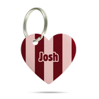 Formgeschnittene Acryl-Hundemarke in Herzform mit bordeauxrotem und rosafarbenem Streifenmuster, personalisiert mit dem Namen „Josh“ und silbernem Schlüsselring auf weißem Hintergrund.