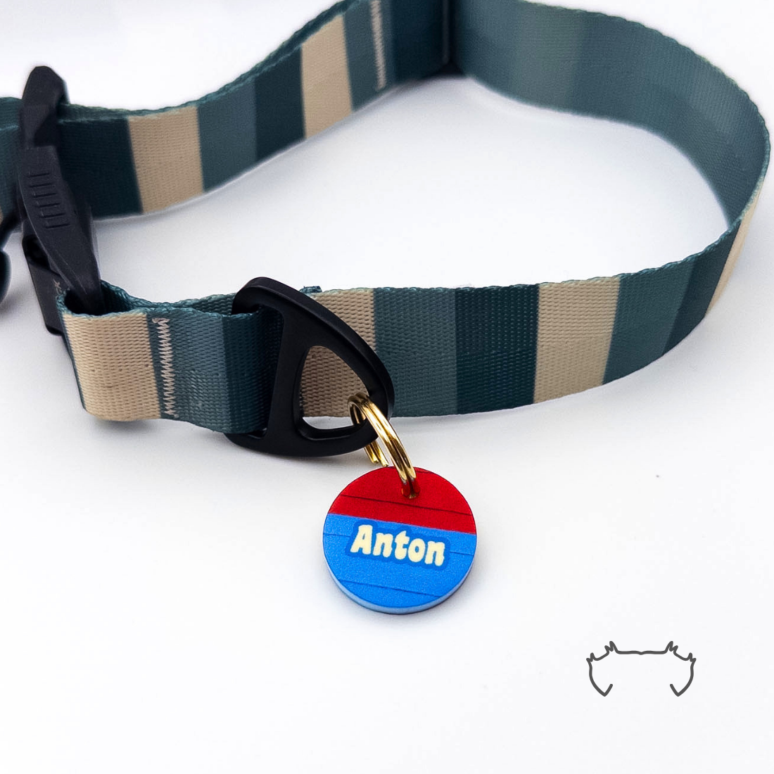 Personalisierte runde Acryl-Hundemarke im Agility-Hundesport-Design in Blau und Rot, befestigt an einem dunkelgrün-beige gestreiften Hundehalsband.