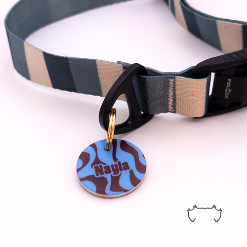 Personalisierte runde Acryl-Hundemarke mit blau-bordeauxfarbenem Wellenmuster und Name, befestigt an einem dunkelgrün-beige gestreiften Hundehalsband mit schwarzem Verschluss.