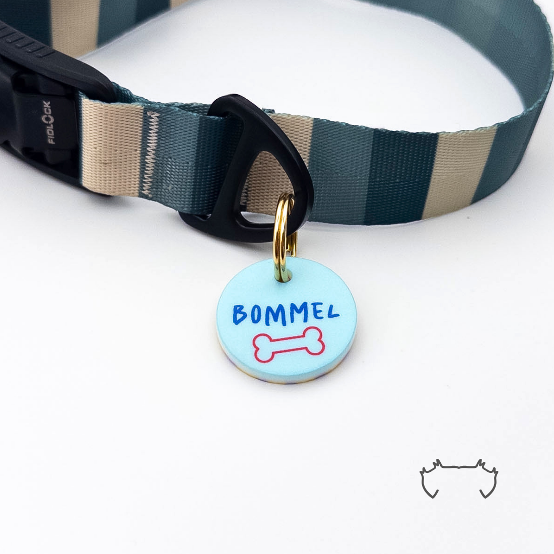 Personalisierte runde Acryl-Hundemarke mit hellblauem Knochenmotiv und Namen, befestigt an einem dunkelgrün-beige gestreiften Hundehalsband mit schwarzem Verschluss.