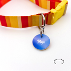 Runde personalisierte Acryl-Hundemarke mit blauem Farbverlauf und weißem Namen, befestigt an einem rot-gelb gestreiften Hundehalsband mit gelbem Verschluss.
