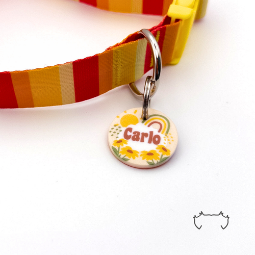 Runde Acryl-Hundemarke mit Boho-Regenbogen-Design, warmen Gelb- und Orangetönen und personalisiertem Namen, befestigt an einem rot-gelb gestreiften Hundehalsband.