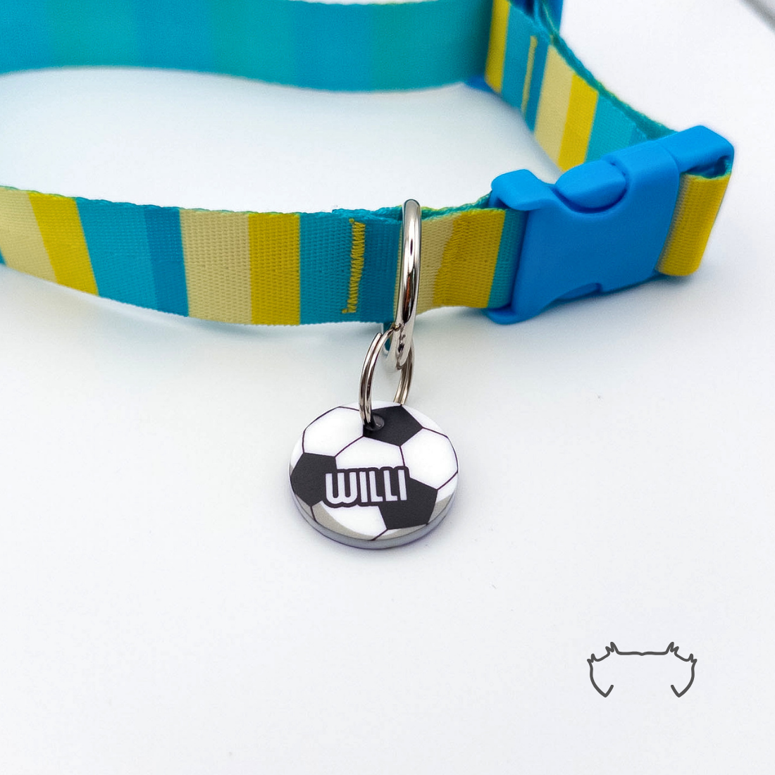 Runde personalisierte Acryl-Hundemarke im schwarz-weißen Fußball-Design, befestigt an einem türkis-gelb gestreiften Hundehalsband mit blauem Verschluss.