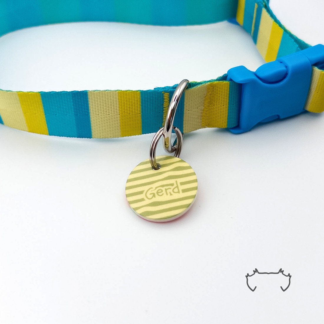 Runde personalisierte Acryl-Hundemarke mit grün-gelbem Streifenmuster, befestigt an einem türkis-gelb-beige gestreiften Hundehalsband mit blauem Verschluss.