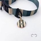 Runde personalisierte Acryl-Hundemarke mit grün-khaki-beigem Streifenmuster, befestigt an einem dunkelgrün-beige gestreiften Hundehalsband mit schwarzem Verschluss.