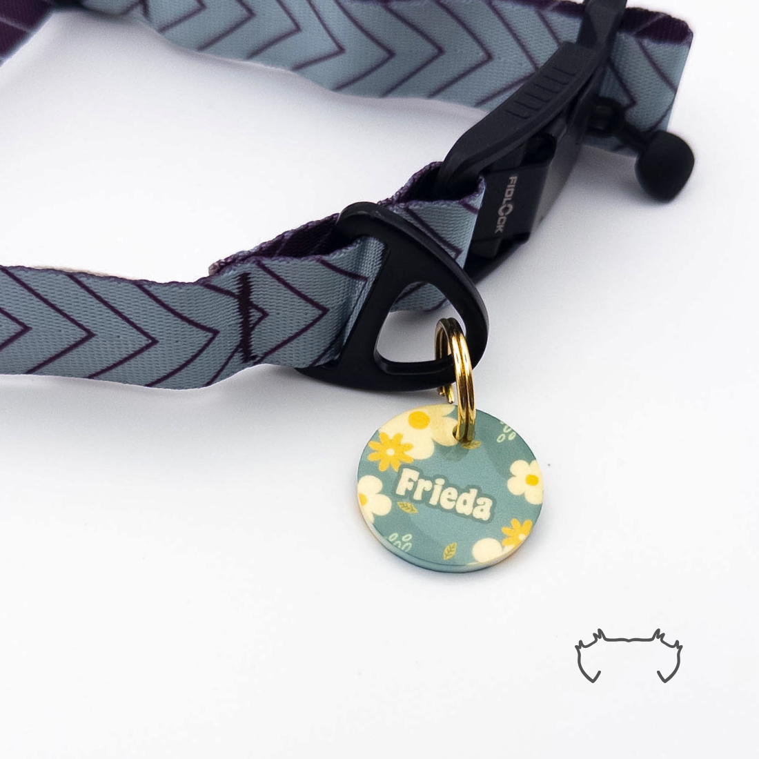 Runde personalisierte Acryl-Hundemarke mit grün-gelbem Blumenmuster, befestigt an einem grauen Hundehalsband mit dunklem Chevron-Muster und schwarzem Verschluss.