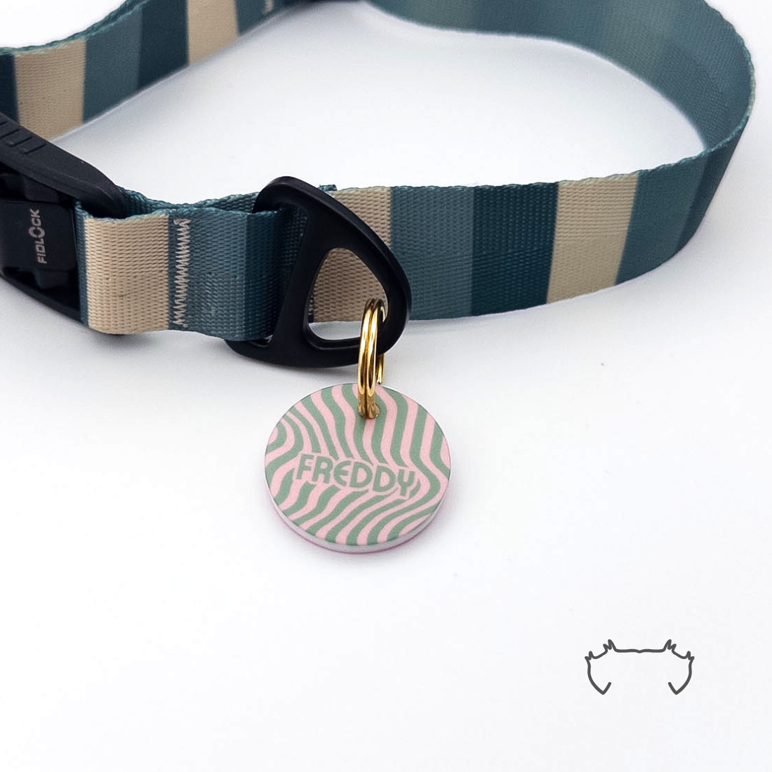 Personalisierte runde Hundemarke aus Acryl mit grün-rosa Wellenmuster, befestigt an einem dunkelgrün-beige gestreiften Hundehalsband mit schwarzem Verschluss.