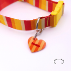 Formgeschnittene Acryl-Hundemarke in Herzform mit orange-gelbem Streifenmuster, befestigt an einem rot-gelb gestreiften Hundehalsband mit gelbem Verschluss. Leichte, bunte Hundemarke für Hunde mit personalisiertem Namen.