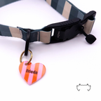 Orange-rosa gestreifte Acryl-Hundemarke in Herzform, befestigt an einem dunkelgrün-beige gestreiften Hundehalsband mit schwarzem Verschluss.