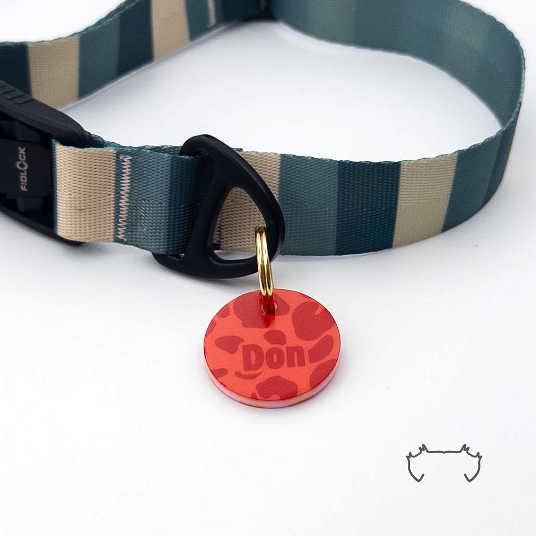 Runde personalisierte Acryl-Hundemarke im roten Leopard-Muster, befestigt an einem dunkelgrün-beige gestreiften Hundehalsband mit schwarzem Verschluss.
