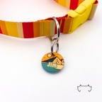 Personalisierte runde Acryl-Hundemarke mit abstraktem Beige-Orange-Petrol-Design, befestigt an einem rot-gelb gestreiften Hundehalsband mit gelbem Verschluss.