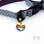 Personalisierte runde Acryl-Hundemarke mit buntem Mountain-Sea-Motiv, befestigt an einem dunklen Hundehalsband mit grafischem Muster und schwarzem Verschluss.