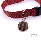 Runde personalisierte Acryl-Hundemarke mit olive-bordeauxfarbenem Streifenmuster und Name „Neo“, befestigt an einem bordeauxroten Hundehalsband mit Chevron-Muster und schwarzem Verschluss.
