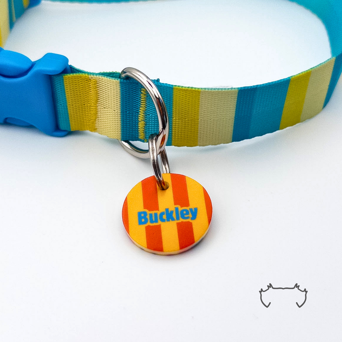 Personalisierte runde Acryl-Hundemarke mit neonfarbenem Streifenmuster in Orange, Gelb und Blau, befestigt an einem türkis-gelb gestreiften Hundehalsband mit blauem Verschluss.