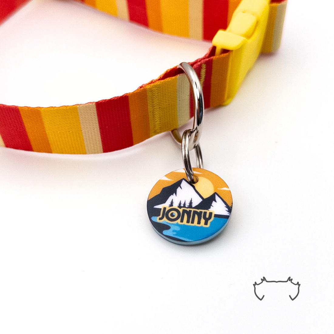 Personalisierte runde Acryl-Hundemarke im gelb-blauen Roadtrip-Design mit Bergmotiv, befestigt an einem rot-gelb gestreiften Hundehalsband mit gelbem Verschluss.