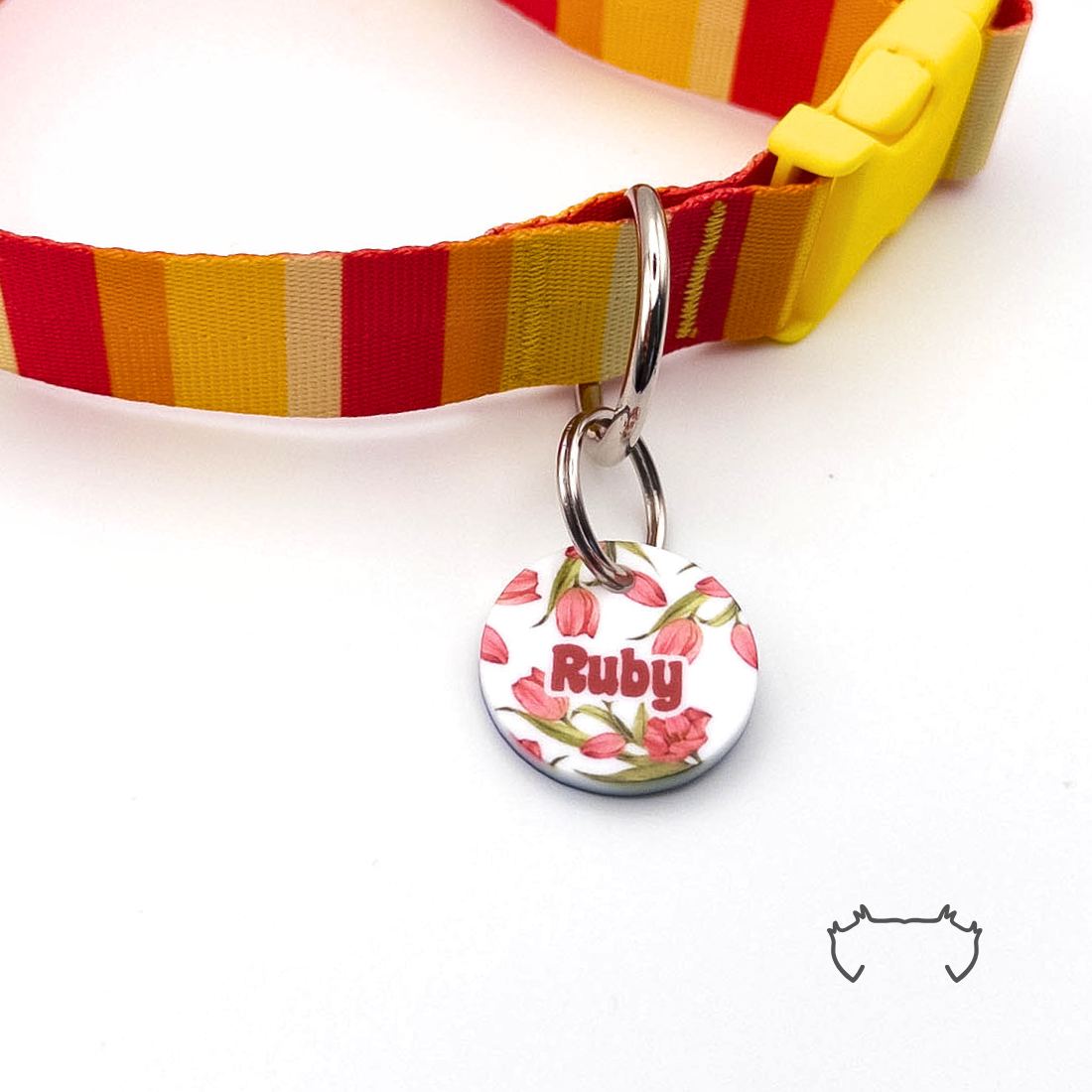 Runde personalisierte Acryl-Hundemarke mit rosa Tulpen-Design und Name, befestigt an einem rot-gelb gestreiften Hundehalsband mit gelbem Verschluss.