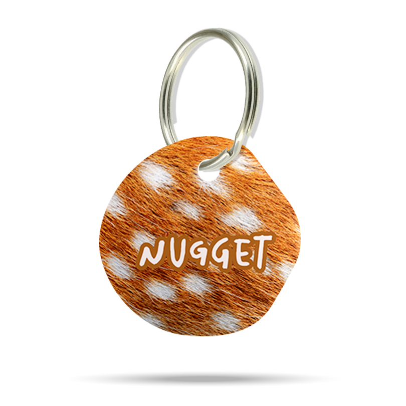 Personalisierte Acryl-Hundemarke in organischer Blob-Form mit braun-weißem Reh Animal Print, Name Nugget und Metallring.