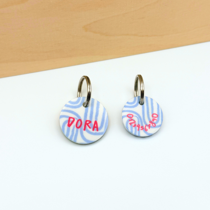 Acryl Hundemarken mit feinem Linien Design in Blau und Pink, personalisiert, leise und klimperfrei, Namensschild mit Namen „Dora“ und zusätzlicher Marke mit Telefonnummer